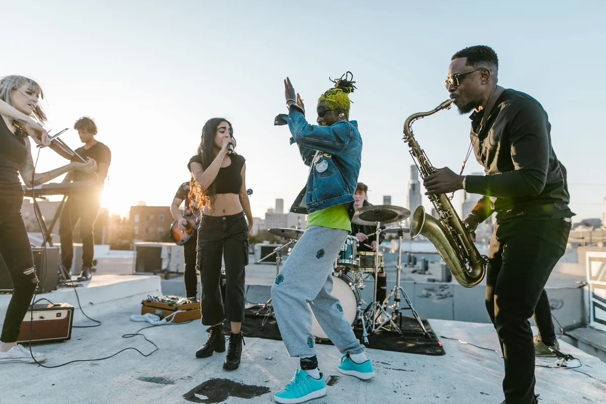 Vibrant music group performing live on a rooftop, showcasing diverse instruments and energetic moves.