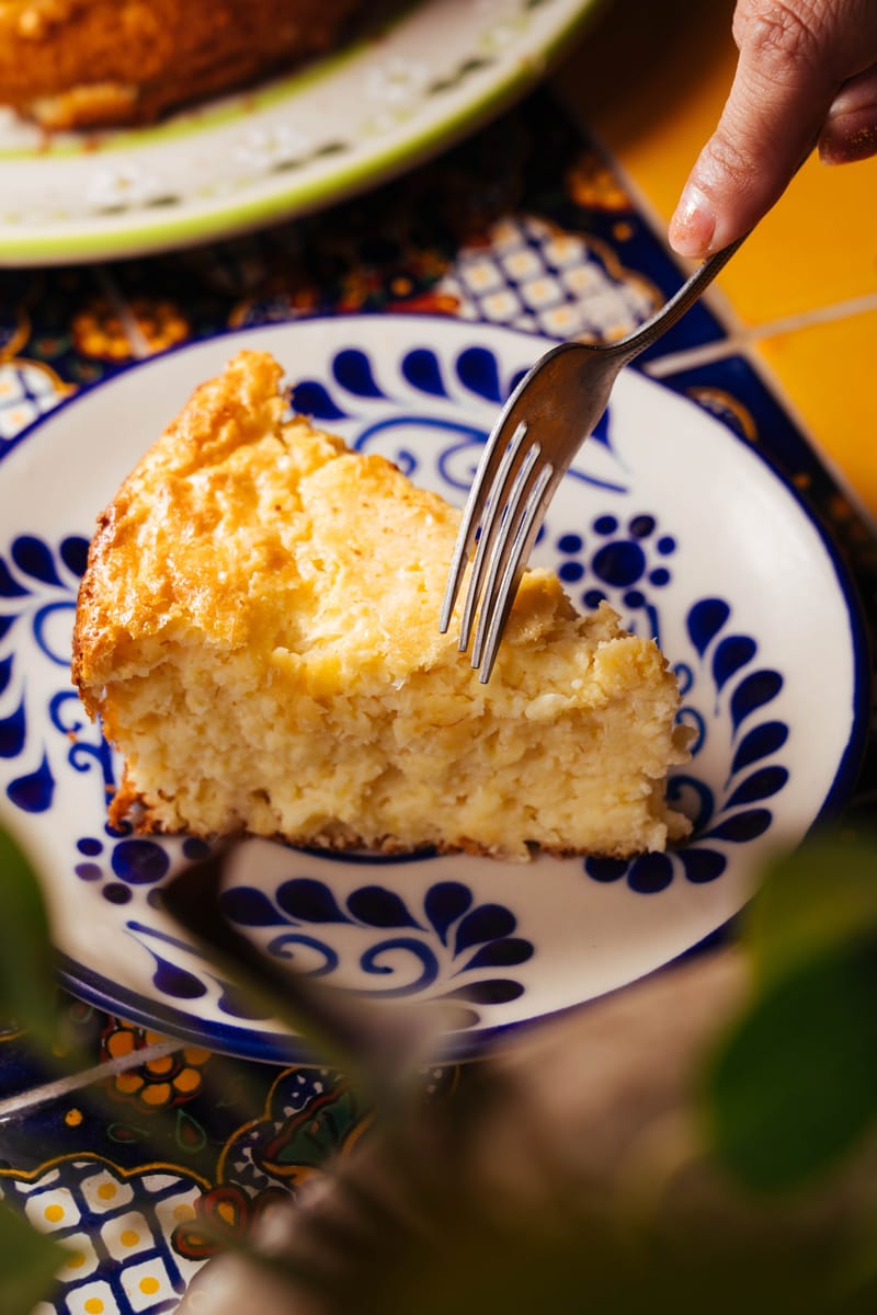 Delicious slice of cheesecake on a colorful plate with intricate designs.